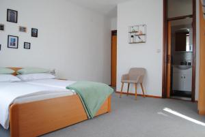 ein Schlafzimmer mit einem Bett und einem Stuhl darin in der Unterkunft Villa Rustika in Malinska