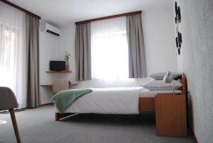 ein Schlafzimmer mit einem Bett und einem großen Fenster in der Unterkunft Villa Rustika in Malinska