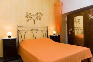 a bedroom with a bed with an orange bedspread at Pepi's Rooms in Triovasálos +33 photos