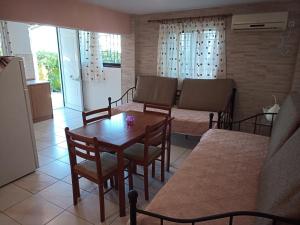 a living room with a table and chairs and a couch at Marietta's Apartments in Agios Andreas