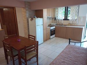 a kitchen with a table and a white refrigerator at Marietta's Apartments in Agios Andreas