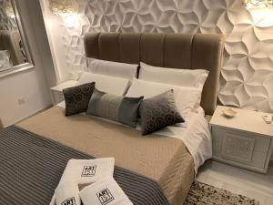 - une chambre avec un grand lit et des oreillers dans l'établissement Artist Terrace Apartments, à Mellieħa