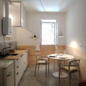 una cucina con tavolo e sedie in una stanza di APT Slow City Hostel a Pontevedra