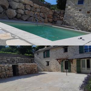 a house with a swimming pool and a stone wall at lou baïto in Condorcet