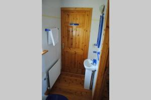 a bathroom with a toilet and a wooden door at Beal alha na Gaoithe in Glenbeigh