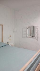 1 dormitorio con cama y espejo en la pared en Casa vacanze Tre stelle, en Termoli