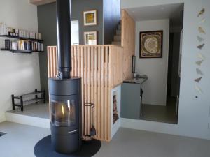 a wood burning stove in a living room with a staircase at La Maison de Madame Baudy in Giverny