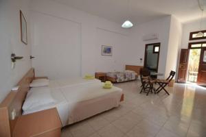 a bedroom with a large bed and a table and chairs at PHILIPPOS STUDIOS & APT in Lindos