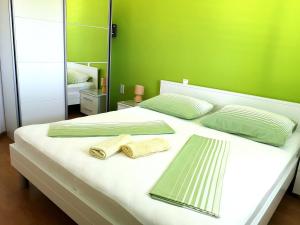 a bedroom with a bed with two towels and a mirror at Apartment Vucic in Makarska