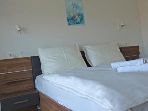 a bed with white sheets and pillows in a bedroom at Villa Papalina 3 in Barbat na Rabu