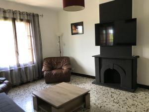 sala de estar con sofá y chimenea en APPARTEMENT TOUT CONFORT AVEC PARKING FERMÉ en Arlés