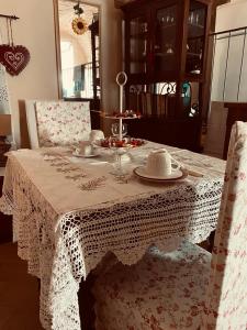 a dining room table with a white lace table cloth at LA GUARDIOLA DEL TEMPIO in Perugia