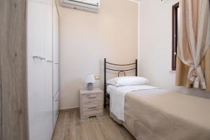 a bedroom with two beds and a dresser and a window at Casa del Marinaio House in Avola