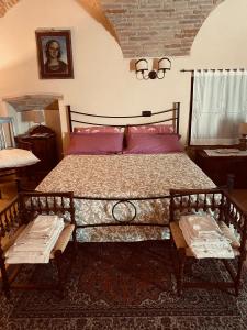 a bedroom with a large bed with two benches at LA GUARDIOLA DEL TEMPIO in Perugia