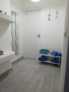 a bathroom with white walls and a wooden floor at Villa Anna Maria in Capo Vaticano