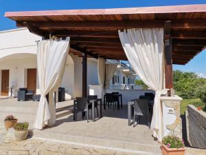 a wooden pergola with white curtains on a patio at Tenuta Turchi in Otranto
