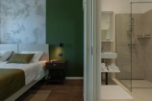 a bedroom with a bed and a shower at Villa Aurum Health & Climatotherapy Center in Rovinj