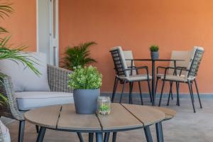 een patio met 2 tafels en stoelen met planten bij Villa Aurum Health & Climatotherapy Center in Rovinj