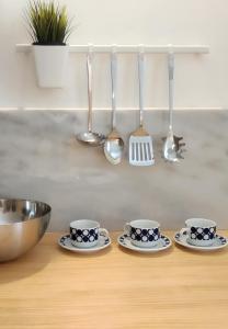 un bancone della cucina con tre tazze e cucchiai di APT Slow City Hostel a Pontevedra
