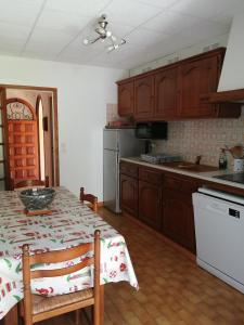 een keuken met houten kasten en een tafel met een tafelkleed bij Arrantzaleak in Hendaye