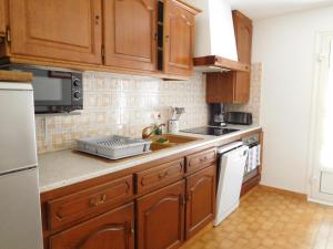 a kitchen with wooden cabinets and a counter top at Arrantzaleak in Hendaye