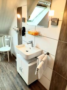 a bathroom with a sink and a mirror at Hotel Pellmühle in Jever