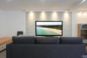 a living room with a couch and a tv on a brick wall at Via Mare in Ginosa Marina