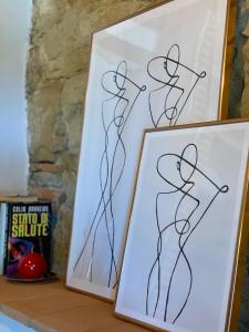 two framed drawings of a woman on a shelf at Il Cerro in Arezzo