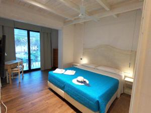 1 dormitorio con 1 cama con sombrero en Villa La Conchiglia Rooms, en Cala Liberotto