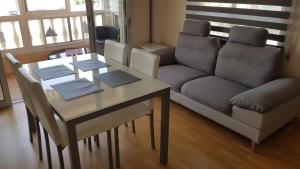 - un salon avec une table et un canapé dans l'établissement Apartamento con tres dormitorios Vista Mar, à Santa Pola