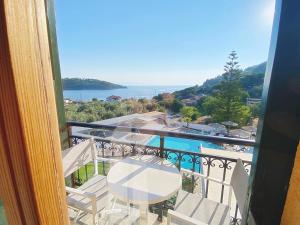 a balcony with a table and chairs and the ocean at Panormos Beach Hotel Skopelos in Panormos Skopelos