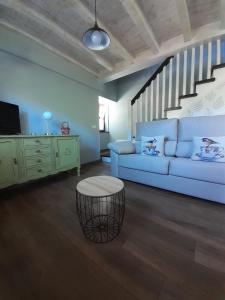 sala de estar con sofá azul y escalera en La Vierta Casa Rural Agroturismo, en Ribadesella