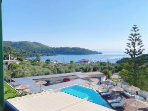a view of a resort with a swimming pool and the ocean at Panormos Beach Hotel Skopelos in Panormos Skopelos