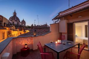 The Right Place 4U Roma Navona Terrace Luxury Rooms في روما: غرفة مع شرفة مع طاولة وكراسي