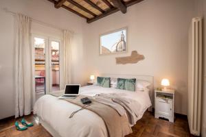 The Right Place 4U Roma Navona Terrace Luxury Rooms في روما: غرفة نوم مع سرير مع لاب توب عليه