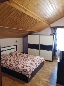 a bedroom with a bed and a wooden ceiling at Vila GABY Mangalia in Mangalia
