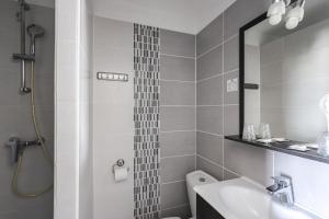a bathroom with a shower and a sink and a mirror at Hotel Les Palmiers En Camargue in Saintes-Maries-de-la-Mer