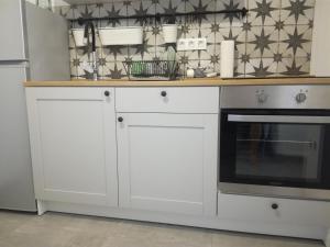 a kitchen with white cabinets and an oven at Apartment Mila Krk in Krk