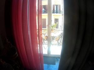 uma vista para uma varanda a partir de uma janela com cortinas vermelhas em B&B Lex Room Santa Lucia em Nápoles