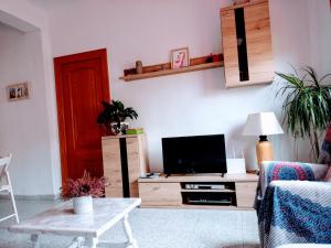een woonkamer met een tv en een tafel bij PISO ACOGEDOR Y ALEGRE EN CASTELLÓN in Castellón de la Plana