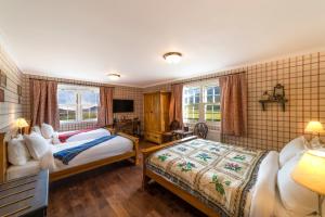 a hotel room with two beds and a television at The Cluanie Inn in Glenmoriston