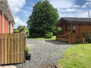 una cabaña de madera con una valla al lado de un patio en The Cabin @ Willowmere (Garden Log Cabin), en Clane