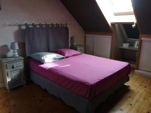 una camera da letto con un grande letto con lenzuola e cuscini rosa di Les Eléphants bleus a Onzain