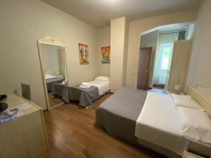 een hotelkamer met 2 bedden en een spiegel bij Hotel Edoné in Roe