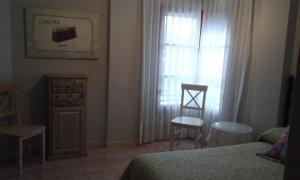 a bedroom with a bed and two chairs and a window at apartamento Valles Blancos 3-6 in Biescas