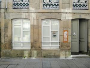 duas janelas do lado de um edifício em APT Slow City Hostel em Pontevedra