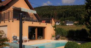a house with a swimming pool and a balcony at Notre Rêve - Chambre d'hôtes in Marmoutier