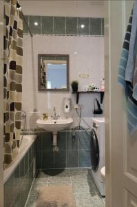 a bathroom with a sink and a tub and a toilet at The Monk's Bunk Kaunas in Kaunas