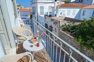 a balcony with a table and chairs on a balcony at Livin Hydra Private Collection Suite 3 in Hydra