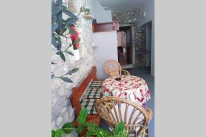 einen Tisch und Stühle in einem Zimmer mit einer Steinmauer in der Unterkunft Apartment Bibić - Hvar center old town in Hvar